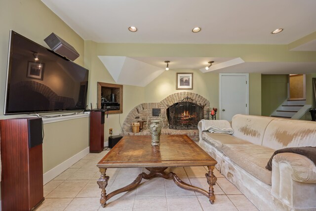 tiled living room featuring a fireplace and lofted ceiling