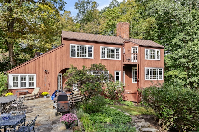 back of property featuring a balcony and a patio