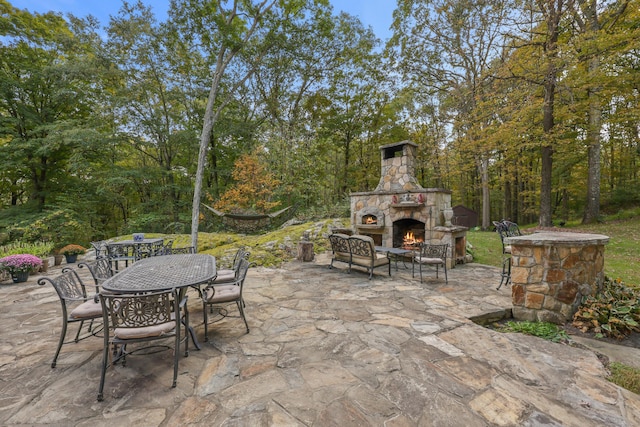 view of patio featuring an outdoor stone fireplace and outdoor dining area