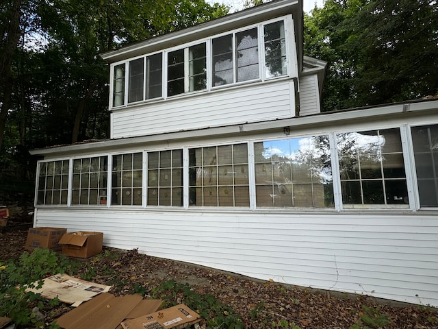 view of property exterior with a sunroom