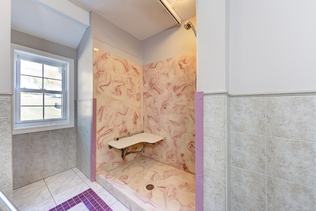 bathroom featuring tile patterned flooring, tile walls, and a shower