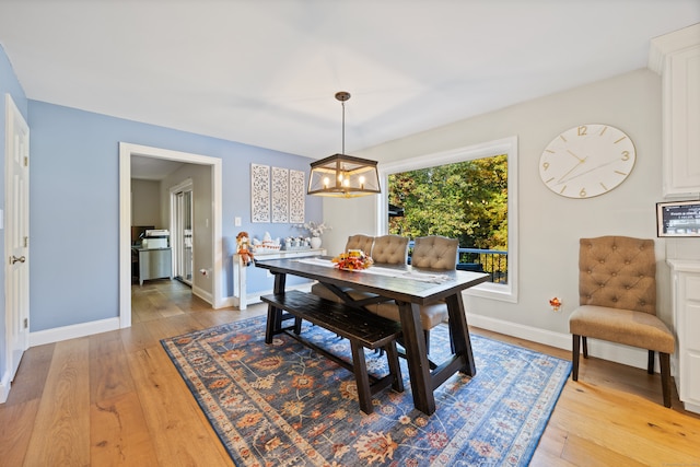 dining space with light wood-type flooring and a chandelier