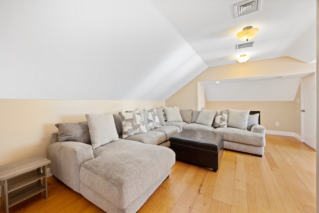 living room featuring lofted ceiling and hardwood / wood-style floors