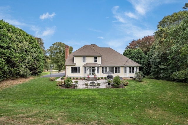 back of house with a patio area and a lawn