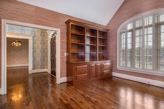 unfurnished living room with a chandelier, built in shelves, dark wood-type flooring, and vaulted ceiling