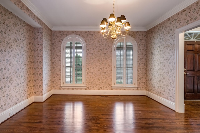 empty room featuring crown molding, dark wood-type flooring, and an inviting chandelier