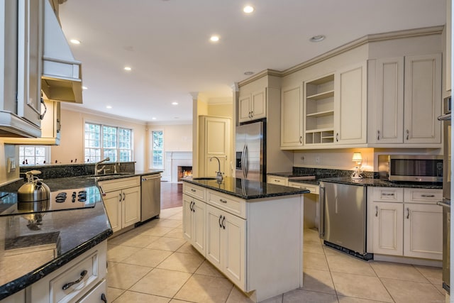 kitchen featuring crown molding, an island with sink, light tile patterned flooring, and appliances with stainless steel finishes