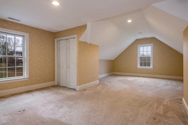 bonus room featuring light carpet and vaulted ceiling