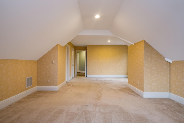 bonus room with vaulted ceiling and carpet floors