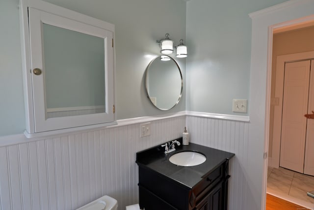 bathroom with toilet, vanity, and wood-type flooring