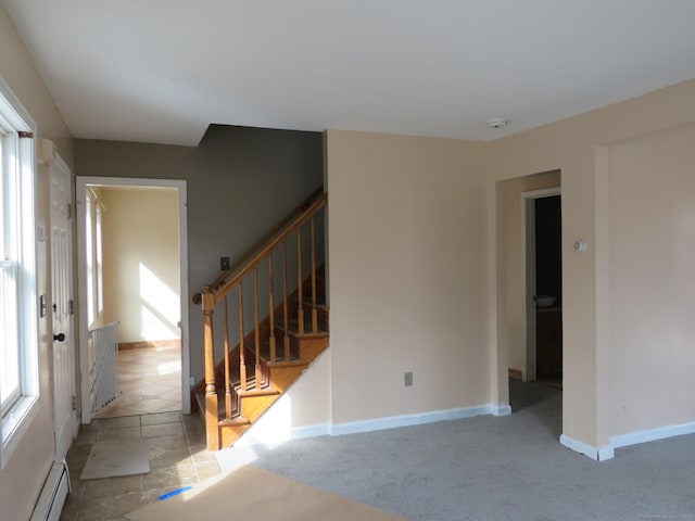 unfurnished room with carpet floors, stairway, baseboards, and a baseboard heating unit