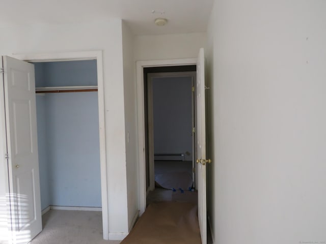 unfurnished bedroom with a baseboard radiator and a closet