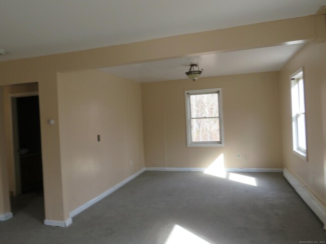 carpeted empty room with a baseboard radiator and baseboards