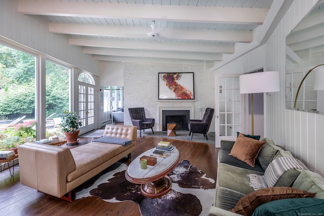 living room with beamed ceiling, wooden walls, a fireplace, french doors, and hardwood / wood-style flooring