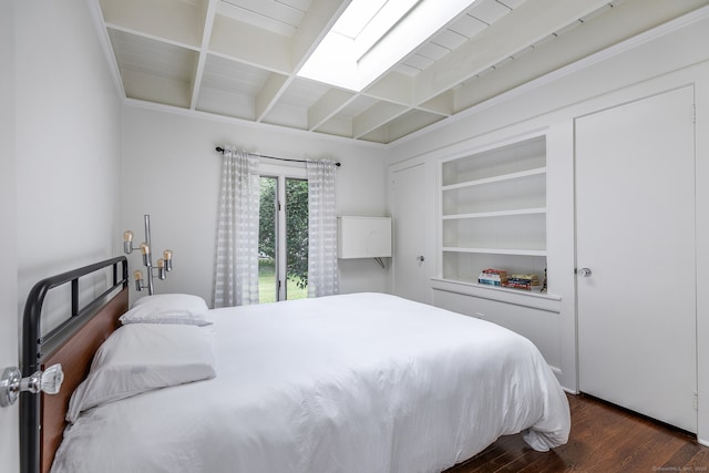 bedroom with a skylight, beam ceiling, and dark wood-type flooring