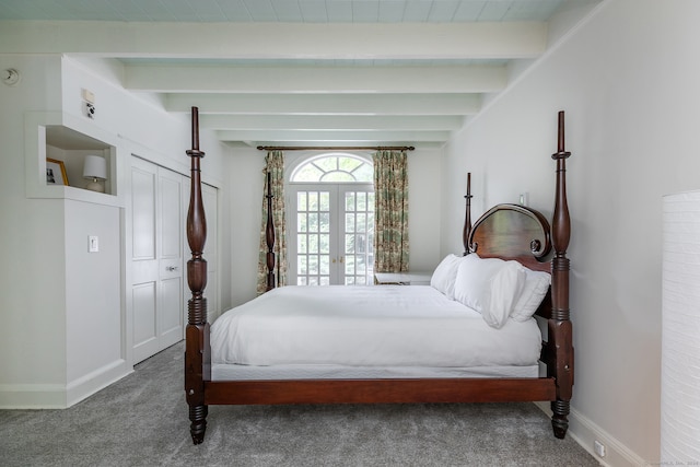 carpeted bedroom with french doors and beamed ceiling