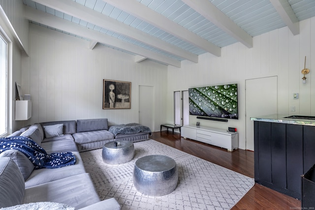 living room featuring beamed ceiling and dark wood-type flooring