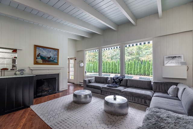 living room with beamed ceiling, wood walls, and dark hardwood / wood-style floors