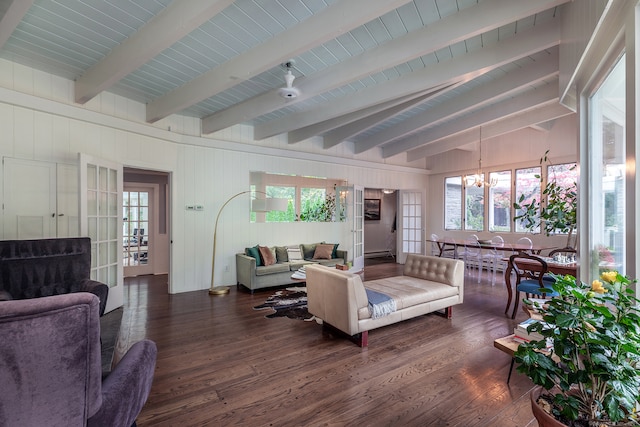 living room with beam ceiling, wood walls, a chandelier, and dark hardwood / wood-style floors