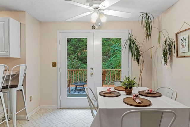 dining space featuring a textured ceiling, ceiling fan, and french doors