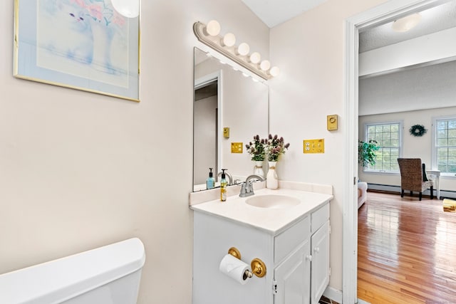 bathroom featuring wood-type flooring, a textured ceiling, vanity, and toilet