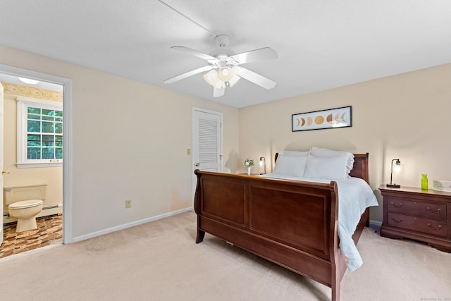 carpeted bedroom with ceiling fan, a baseboard radiator, and ensuite bathroom