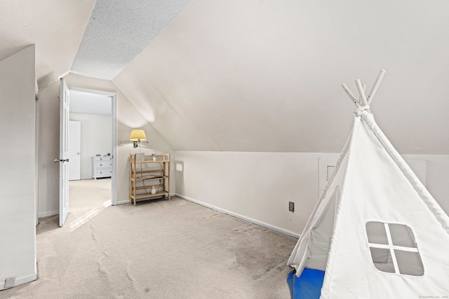 additional living space with a textured ceiling, carpet, and lofted ceiling