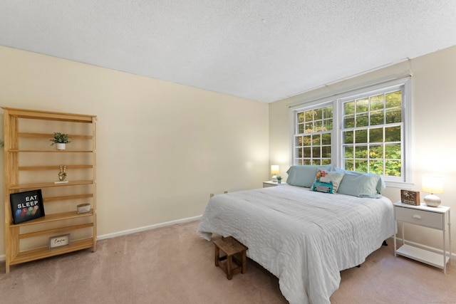 bedroom featuring light carpet and a textured ceiling