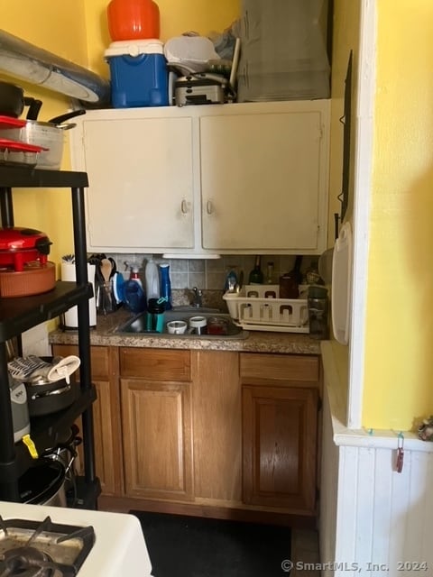 kitchen with decorative backsplash, range, and sink