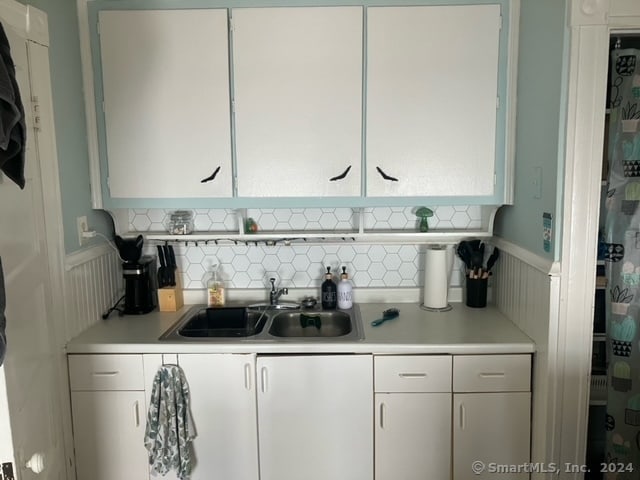 kitchen with white cabinets, sink, and decorative backsplash