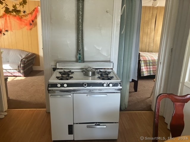 kitchen featuring hardwood / wood-style flooring and white gas stove