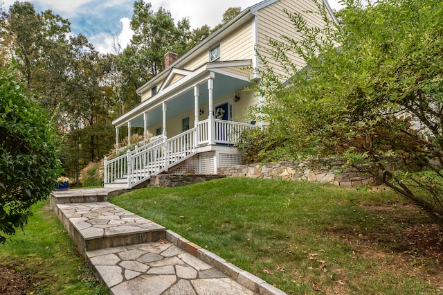 exterior space featuring a lawn and covered porch