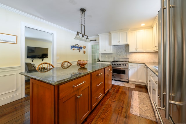 kitchen with hanging light fixtures, white cabinetry, high end appliances, dark hardwood / wood-style flooring, and crown molding