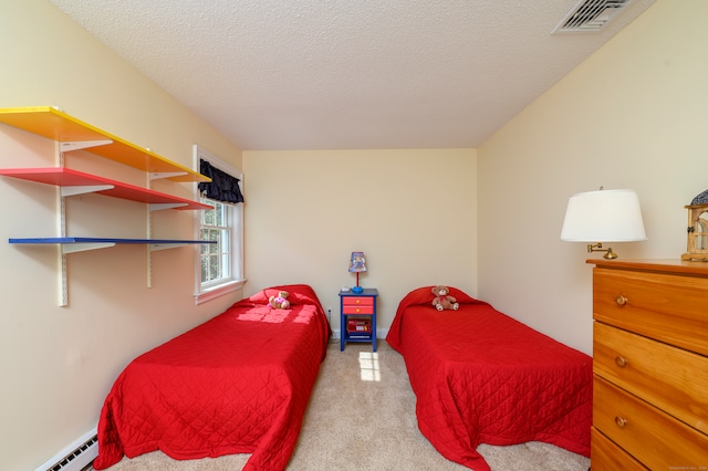 carpeted bedroom featuring a textured ceiling and a baseboard heating unit