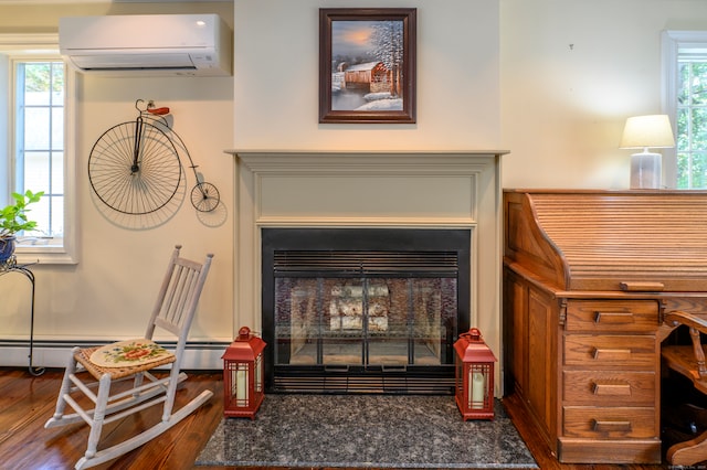 interior details with an AC wall unit, a baseboard radiator, and hardwood / wood-style flooring