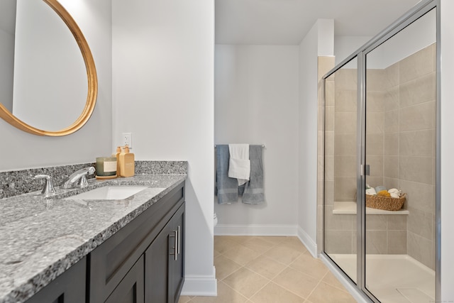 bathroom featuring vanity, a shower with door, and tile patterned floors