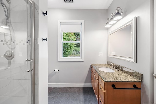 full bathroom with a stall shower, visible vents, baseboards, and vanity