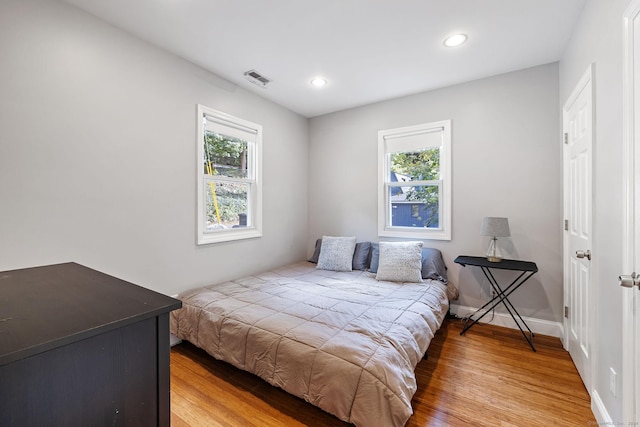 bedroom featuring light wood-type flooring, baseboards, visible vents, and recessed lighting