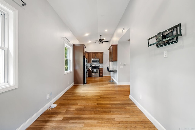 hall with light wood-type flooring, lofted ceiling, baseboards, and recessed lighting