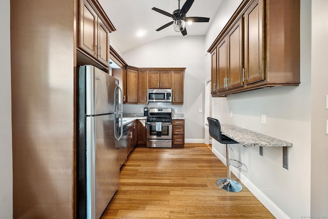 kitchen featuring stainless steel appliances, light wood-style floors, ceiling fan, light stone countertops, and baseboards