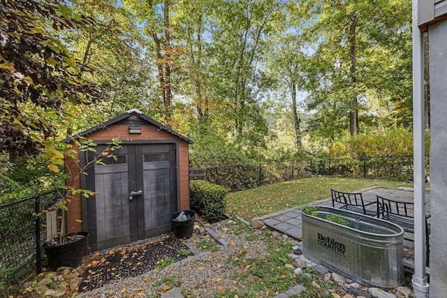 view of yard with a storage shed, a fenced backyard, and an outbuilding