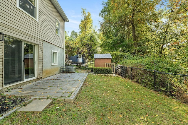 view of yard featuring an outbuilding, a shed, a patio area, and a fenced backyard