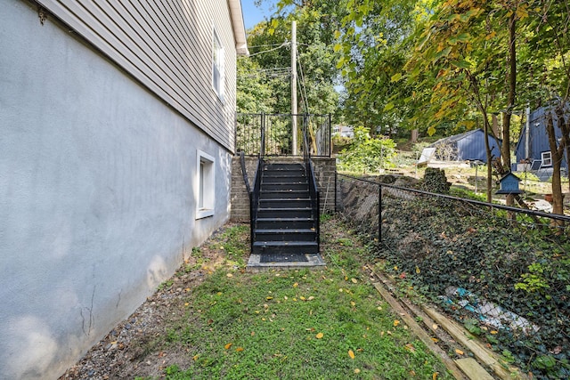 view of yard featuring fence and stairway