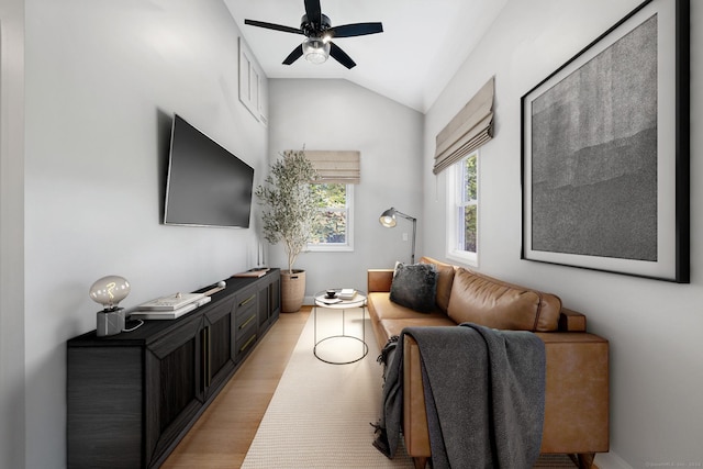 living room with vaulted ceiling, ceiling fan, and light wood finished floors