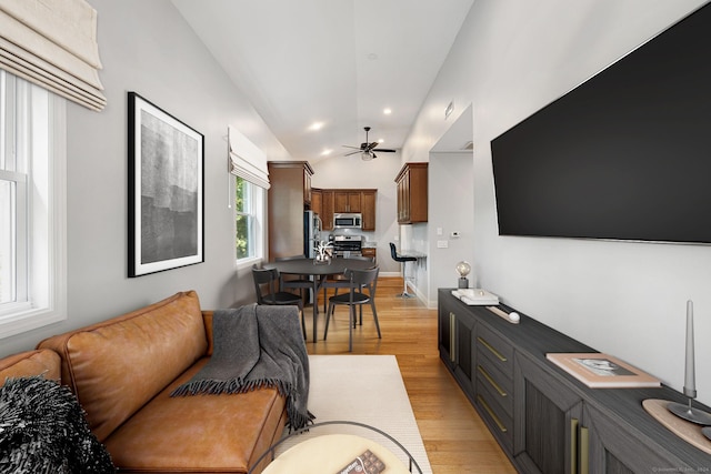 living area featuring light wood-type flooring, ceiling fan, vaulted ceiling, and recessed lighting