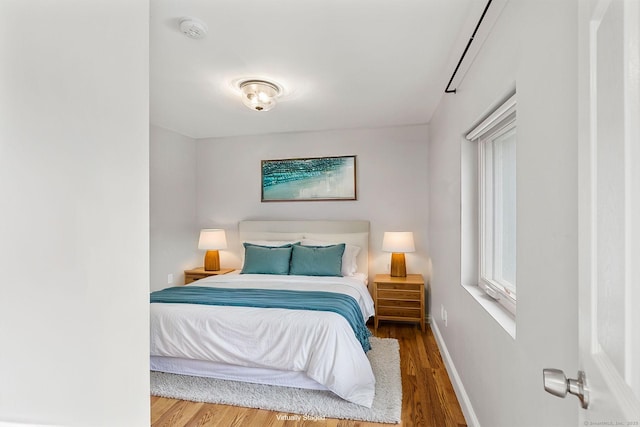 bedroom with baseboards and wood finished floors