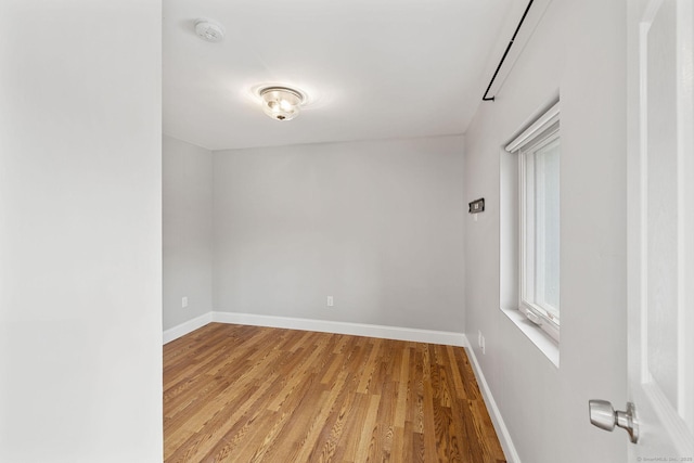 empty room featuring light wood finished floors and baseboards