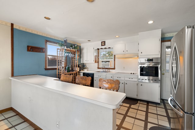 kitchen featuring white cabinets, stainless steel appliances, and a wealth of natural light