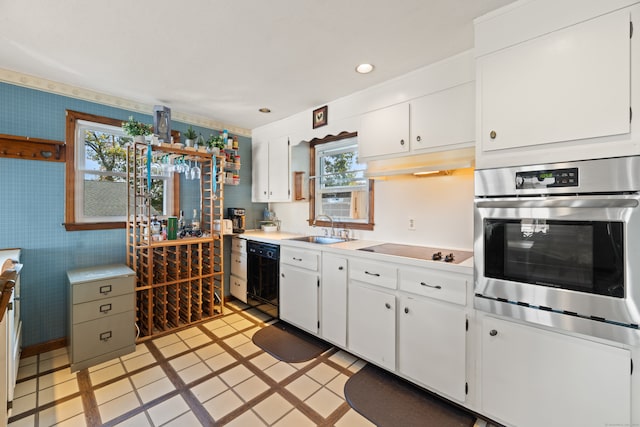 kitchen featuring sink, black appliances, white cabinets, and light tile patterned flooring