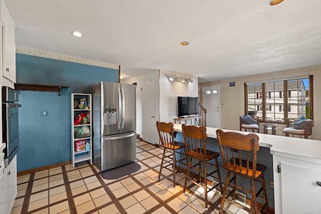 kitchen with white cabinets, stainless steel appliances, and light tile patterned flooring